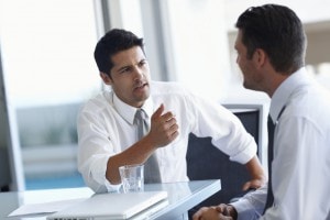 Two young businessmen brainstorming together at the office